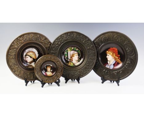 Three French ceramic portrait plates, late 19th/early 20th century, each set to a pressed patinated metal border with hanging