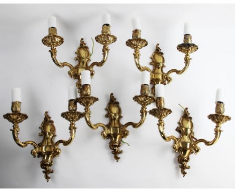 A set of five French brass rococo style twin branch wall light fittings, mid 20th century, of typical scrolling foliate form 