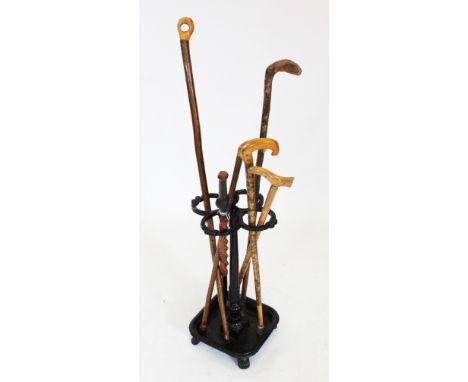 A Victorian cast iron stick stand, stamped 'W H &amp; Co', the quatreform stick compartment guards raised upon a tapering flu
