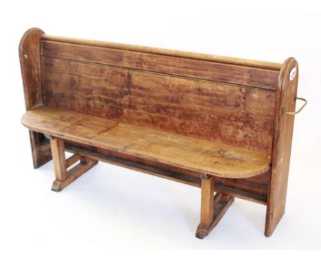 A Victorian pitch pine church pew, with moulded arched end supports enclosing the board seat and back rest, oval enamelled '2