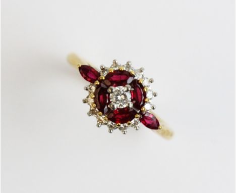 A ruby and diamond 18ct gold cluster ring, comprising a central round brilliant cut diamond weighing approx. 0.10ct, with a c