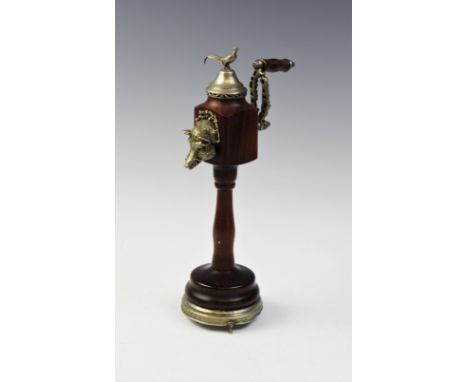 A novelty white metal musical pepperette grinder, modelled on a turned wood stand and mounted with a boars mask, cockerel fin