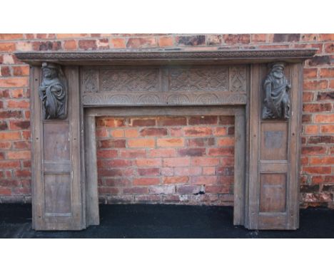 A 17th century style carved oak fire surround, 19th century, the rectangular shelf above panels carved with scrolling detail 