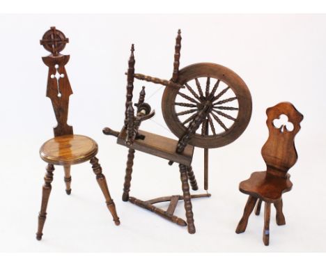 A reproduction oak spinning wheel, 20th century, with a 45cm spindled wheel, raised upon bobbin turned supports, 86cm high, a