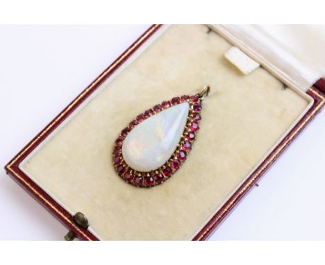 An opal and untested ruby set pendant within a fitted Wartski case, the pear shaped opal (measuring 26mm x 14mm), within a su