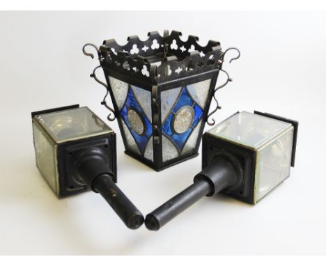 An early 20th century Arts & Crafts wrought iron hanging lantern, the scrolled frieze with trefoil shaped apertures over the 