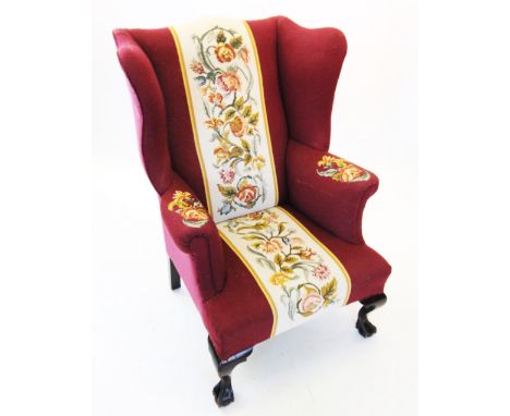 A George III style wing back fireside armchair, late 19th/early 20th century, in burgundy fabric with a central tapestry pane