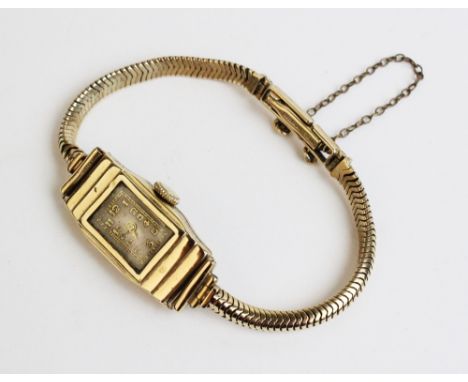 A 9ct gold lady's wristwatch, Birmingham 1954, the rectangular silvered dial with Arabic numerals within a stepped rectangula