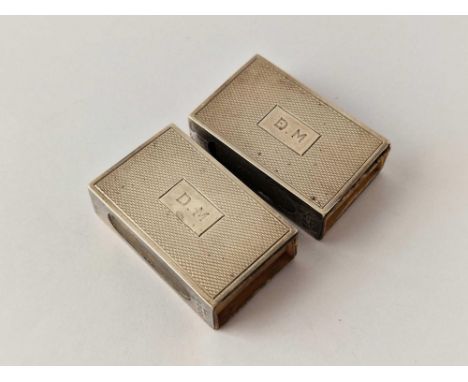 A pair of silver hallmarked matchbox holders, engine turned