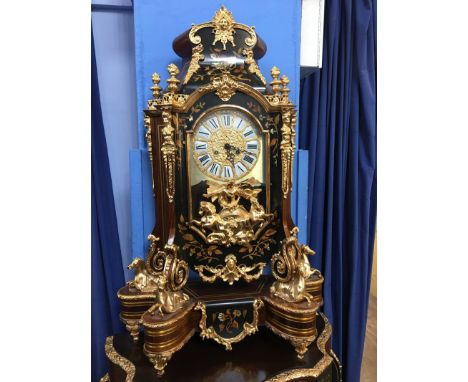 An impressive modern bracket clock with ornate case, decorated with gold coloured horses, supported on an ornate matching gil