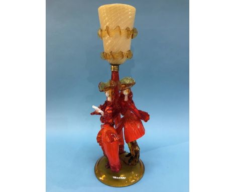 A Murano figural glass table lamp of two ladies wearing orange, below a caramel coloured shade, 52cm height
