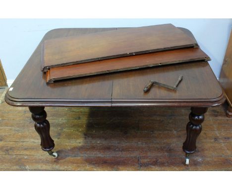 A 19th century stained mahogany winding-extending dining table, of rectangular form with two extra leaves, moulded edge, inve