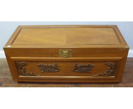A camphor wood trunk of rectangular form, the front decorated with relief moulded scenes of figures and pagodas and the plain