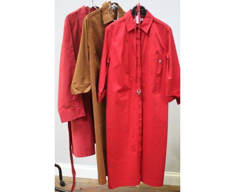 An Aquascutum ladies long red belted trench coat, with button detail, red inside lining, two side front pockets, UK women's s