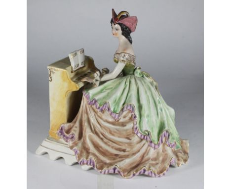 An Italian ceramic figure of a lady playing the piano by Giovanni Girardi, 25cm high 