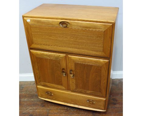 An Ercol blonde elm Windsor 469 shape drinks cabinet, having hinged fall-front enclosing storage space, over two cupboard doo