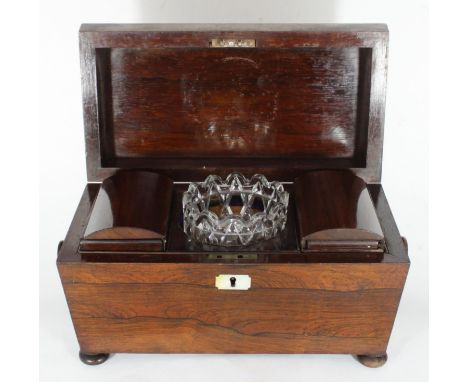 A 19th century rosewood sarcophagus tea caddy, the hinged top enclosing compartmented interior with glass mixing bowl, turned