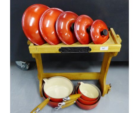 A set of five Le Crueset cooking pots in red enamel complete with pine stand (a lot)