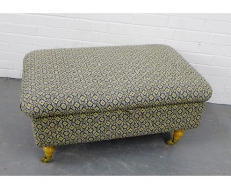 A contemporary blue and beige floral upholstered centre stool, with lift up top, raised on turned supports, terminating in br