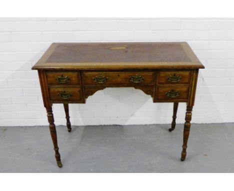 An oak desk,the rectangular top with an inset brown leather skiver, over a single long drawer flanked by a pair of short draw