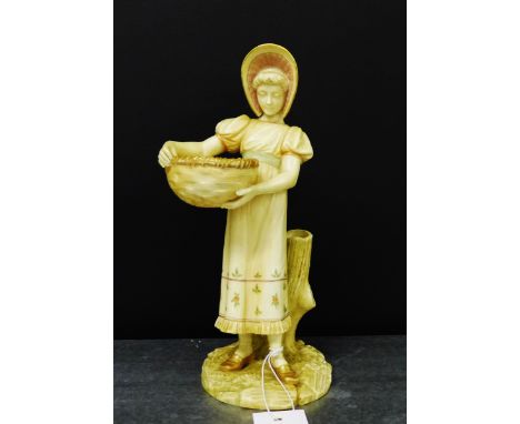 A Royal Worcester blush ivory figure of a young girl in her sun dress and bonnet, carrying a basket, modelled standing by a t