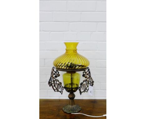 A coppered metal table lamp base with amber glass well and shade 