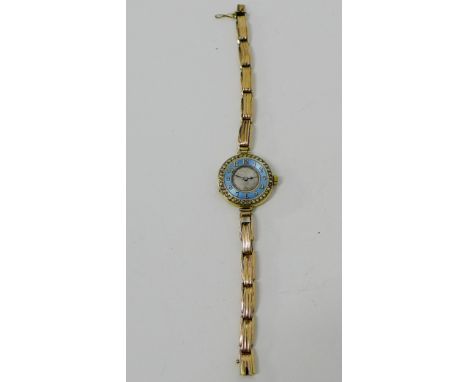 9 carat gold cased cocktail watch with blue enamel chapter ring with Arabic numerals and surround of seed pearls on a yellow 