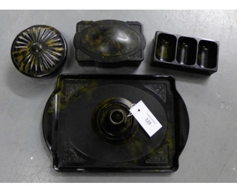 An early 20th century black marbled plastic desk set by Linsden comprising a rectangular tray, circular pot and cover, candle