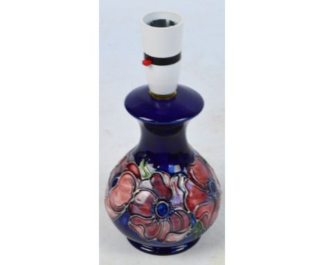 MOORCROFT; a blue ground lamp decorated in the "Pink Clematis" pattern, impressed mark, height including fitment 23cm. CONDIT