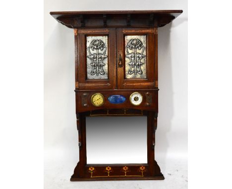 A mahogany Arts and Crafts hanging wall cabinet with jutting bracketed top, strap hinges to two cupboard doors set with pewte