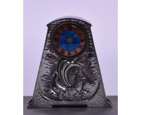 ARCHIBALD KNOX FOR LIBERTY & CO; a Tudric hammered polished pewter mantel timepiece, the shaped case embossed with a galleon 