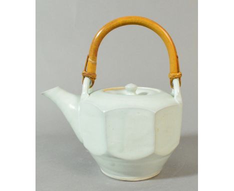 SHIGEYOSHI ICHINO (born 1942) for Leach Pottery; a porcelain cut-sided teapot covered in pale duck egg blue glaze, cane handl