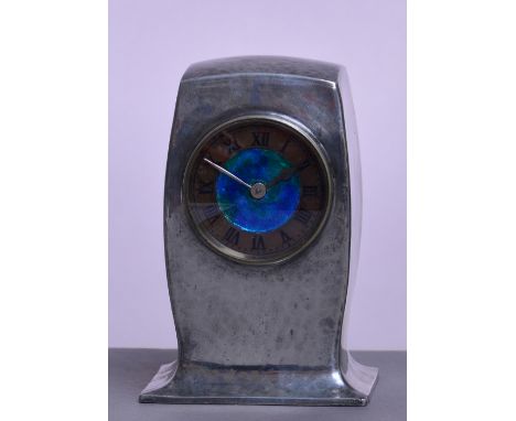 ARCHIBALD KNOX FOR LIBERTY & CO; a hammered pewter mantel timepiece, the rounded rectangular case set with a blue/green ename