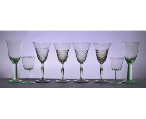 JAMES POWELL WHITEFRIARS; a set of four pale green tinted wine glasses with part cut decorated trumpet shaped bowls, hexagona