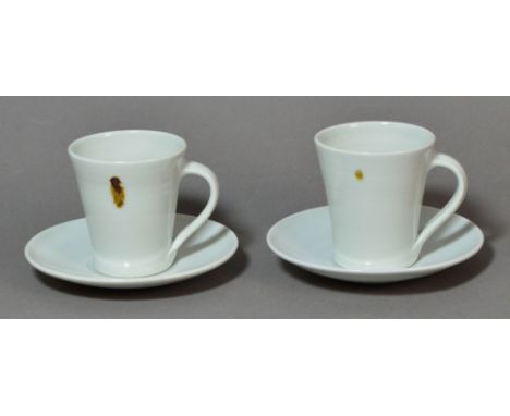 EDWARD HUGHES (1953-2006); a pair of porcelain cups and saucers covered in white glaze with iron spots, impressed EH marks, h