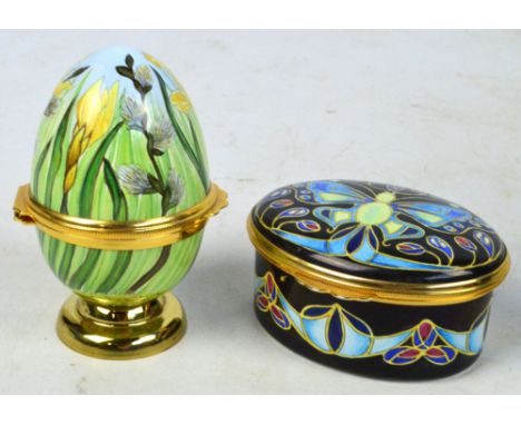 MOORCROFT; a boxed enamelled hinged egg, boxed with small stand and a Moorcroft enamel butterfly decorated oval hinged trinke