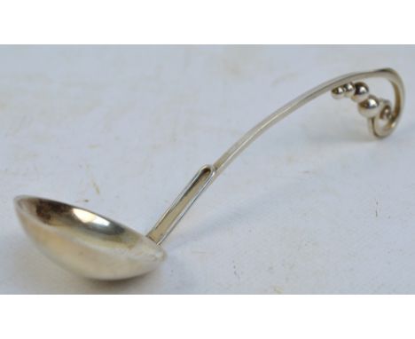 GEORG JENSEN INC.; a small silver sauce ladle with pierced scrolling loop handle and rounded bowl, stamp mark "Made in USA" (