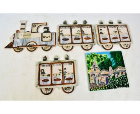 A set of ceramic wall plaques depicting a GWR engine with driver, and three coaches containing passengers, each height approx