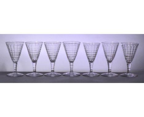 JAMES POWELL WHITEFRIARS; a very near set of seven cut glass wine glasses with conical bowls above octagonal tapering stem an