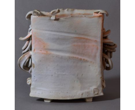 COLIN PEARSON (1923-2007); a square stoneware vase with convoluted wings covered in white glaze with orange highlights, impre