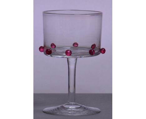 JAMES POWELL WHITEFRIARS; a claret glass designed by Philip Webb, the bucket bowl set with eight applied cranberry tinted pru