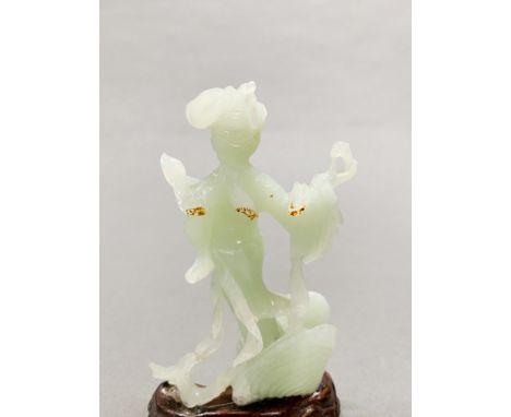 A Chinese carved jade figure of a girl emerging from a shell holding a pearl, H. 15cm. Together with two further green stone 