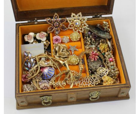 A wooden jewellery box containing a quantity of vintage jewellery to include diamanté brooches, gilt necklaces, earrings etc.