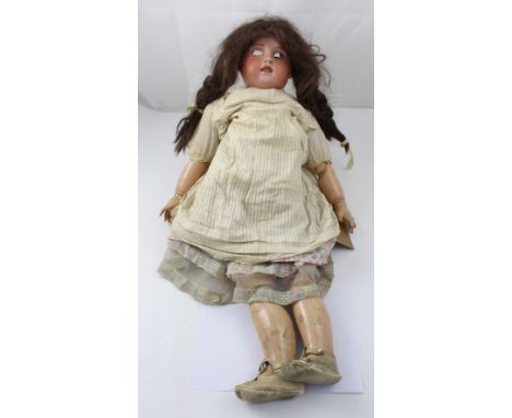 An early 20th century French Jumex Bibe Jumeau Paris doll, ceramic head with, open mouth, composite body, long brown wig and 