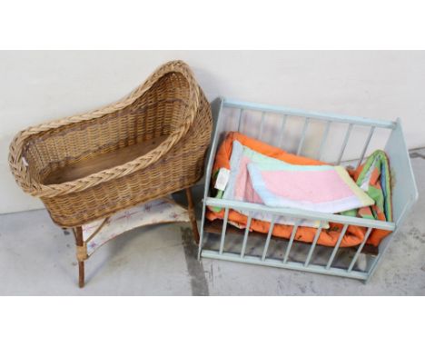 A vintage blue painted dolls' cot with teddy bear decoration, a quantity of baby blankets and a vintage wicker cot with lower