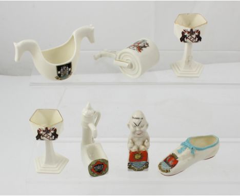 Seven items of crested ware by Goss, Shelley and Carlton to include a garden roller, a water pump, a thumbs up pixie, a pair 