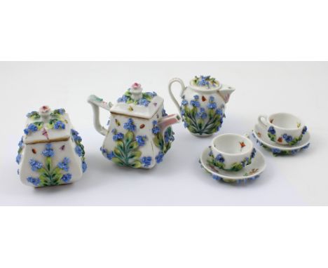 A Dresden miniature forget-me-not floral encrusted tea service comprising two cups and saucers, teapot, height 9cm, sugar bow