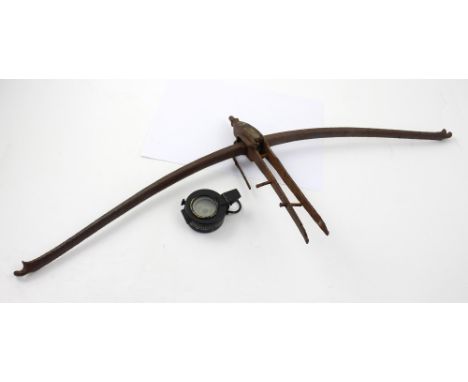 A vintage metal bow from a wooden crossbow, and a WWII military compass by T.G. Co Ltd of London, no.B24021, with broad arrow