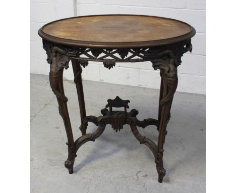 A late 19th/early 20th century Oriental hardwood oval side table, carved frieze of dragons, lattice work and foliage, body of