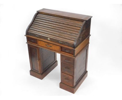 ROLL-TOP DESK. A 1930's child's oak roll-top desk by KM & Co., Manchester. Pigeon hole interior. H86xW70xD41cm.NOTE: Our post